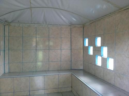 a room with two windows and a tiled wall at Hosteria Mar de Plata in Cabuyal