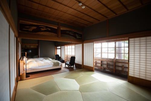 1 dormitorio con cama y ventana en 草木ももとせ 