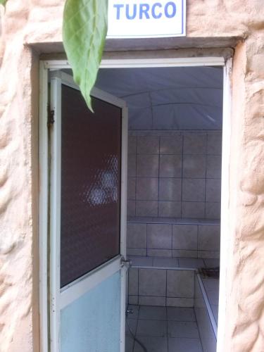 an open door to a tiled bathroom with a sign at Hosteria Mar de Plata in Cabuyal