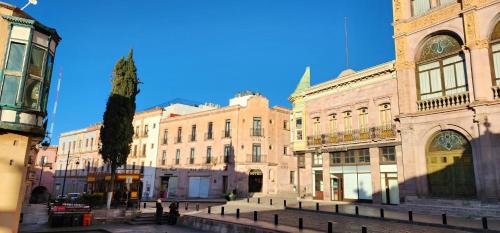 a group of buildings and a tree in a street at HOTEL POSADA DE LA MONEDA in Zacatecas