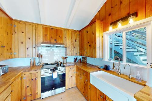 a kitchen with wooden cabinets and a sink and a stove at Euphoria on the Fjord in Hoodsport