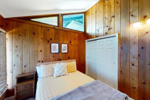 a bedroom with wood paneled walls and a bed at Euphoria on the Fjord in Hoodsport