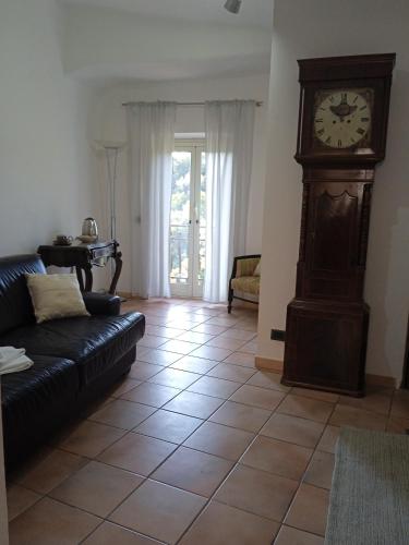 a living room with a grandfather clock and a couch at Casa Lale in Corchiano