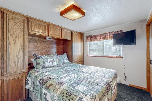 a bedroom with a bed and a flat screen tv at Evergreen #B4 in Brian Head
