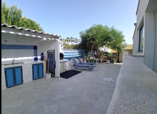 a patio with a bench next to a house at Villa Sunshine in Triscina