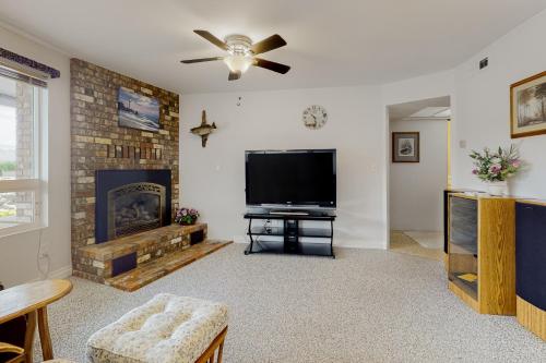 a living room with a flat screen tv and a fireplace at Prime Cove Quarters in Oak Harbor