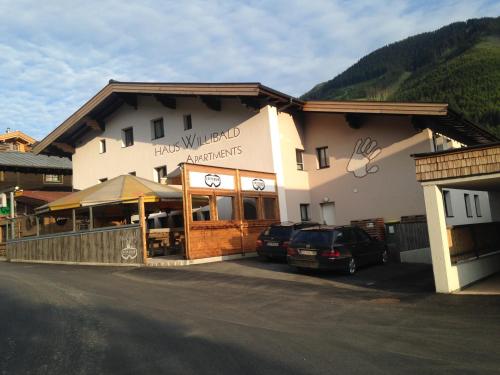 a building with cars parked in front of it at Haus Willibald in Saalbach Hinterglemm