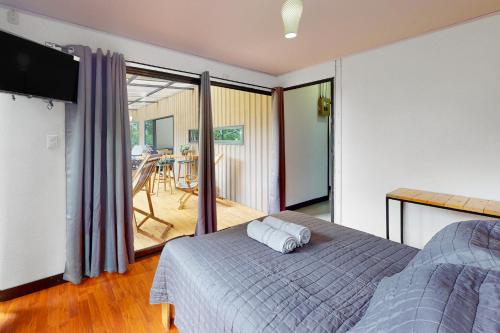 a bedroom with a bed and a balcony with a table at Aqua Tarrazu in Santa Cruz