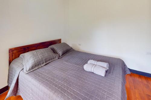 a bedroom with a bed with two towels on it at Aqua Tarrazu in Santa Cruz