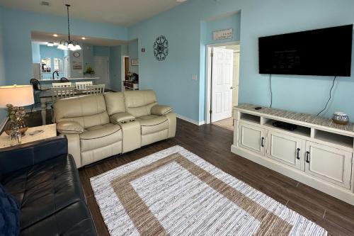 a living room with a couch and a flat screen tv at Cypress Point at Craft Farms #304B in Gulf Shores