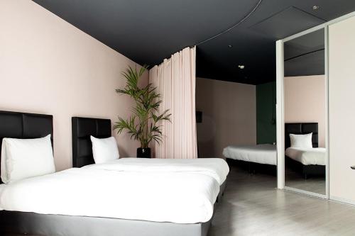 a bedroom with two beds and a mirror at Hotel2Stay in Amsterdam