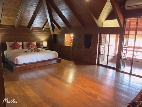 um quarto com uma cama num quarto com pisos em madeira em Lantana House em Ban Pa Muang