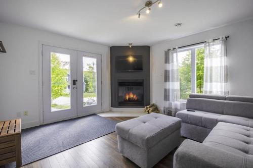 a living room with a couch and a fireplace at Détente Orford 111 condo/chalet in Orford