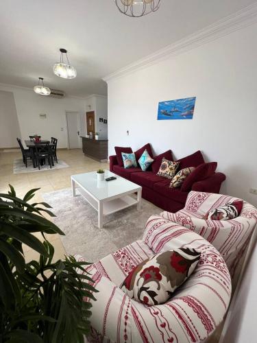 a living room with a red couch and a table at Lilly Apartments in Hurghada