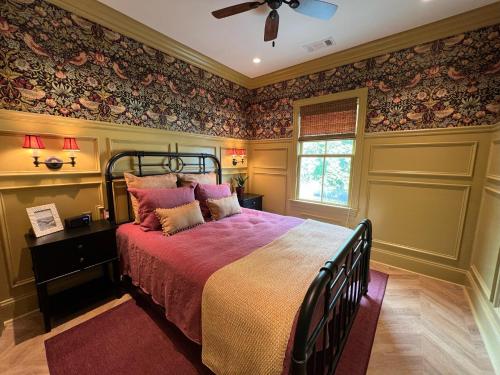 a bedroom with a large bed with floral wallpaper at New Construction Cottage in Downtown Savannah Arts District in Savannah