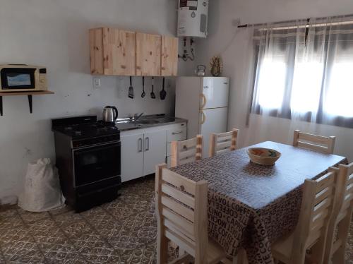 a kitchen with a table with chairs and a stove at La Termenia in Termas de Río Hondo