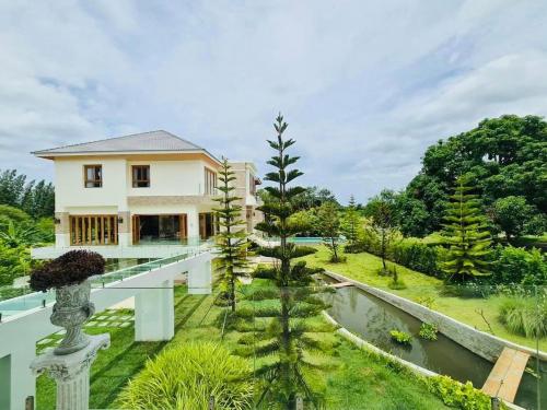 a house with a garden and a pond at Nichahome Luxury Villa in Hua Hin