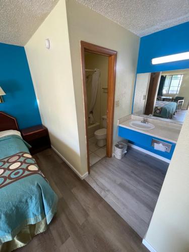 Habitación con cama y baño con lavabo. en Executive Inn, en Mountain Home