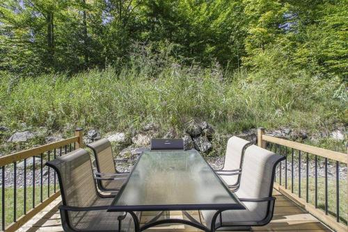 a table and chairs on a deck with a laptop at Grands Espaces Orford 115 condo/chalet in Orford