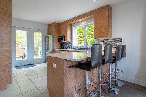 a kitchen with a island with bar stools at Grands Espaces Orford 115 condo/chalet in Orford