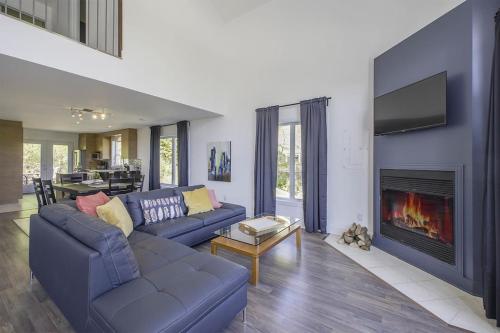 ein Wohnzimmer mit einem Sofa und einem Kamin in der Unterkunft Grands Espaces Orford 115 condo/chalet in Orford