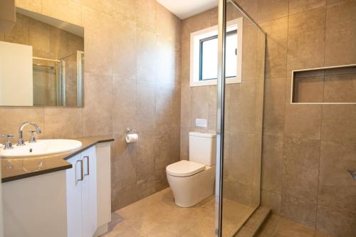 a bathroom with a toilet and a sink and a shower at Joalah Holiday Park in Durras