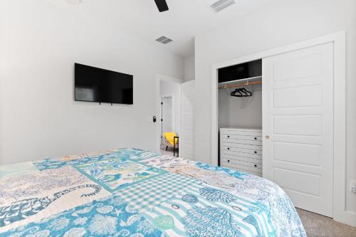 a white bedroom with a bed and a dresser at Serenity Pearl Escape in Saint Augustine