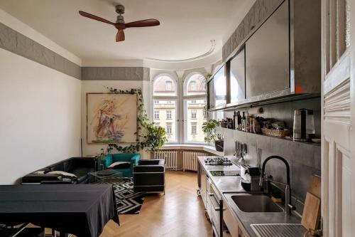 uma cozinha com uma ventoinha de tecto e uma sala de estar em Modern meets Classic - near Volkspark Schöneberg em Berlim