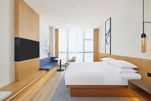 a hotel room with a bed and a tv at Fairfield by Marriott Zibo in Zibo