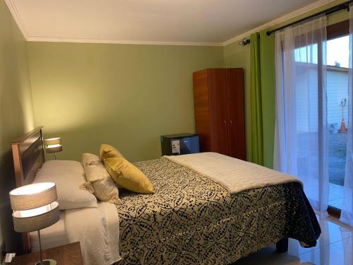 een slaapkamer met een bed met kussens en een raam bij Alojamiento Los Nogales in Santa Cruz