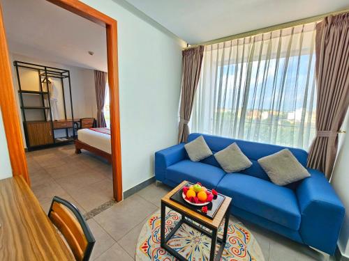 a living room with a blue couch and a window at Le Botum Hotel in Phnom Penh