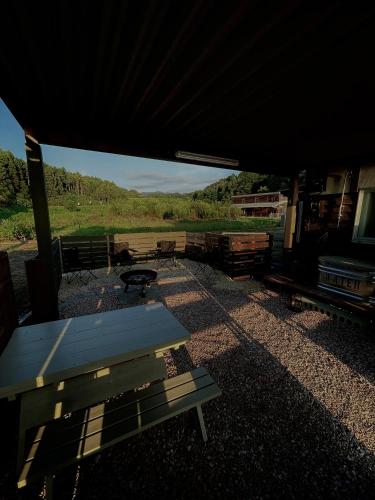 a picnic table sitting under a tent with a view of a field at 一棟貸し宿OH!TOMARI-バレルサウナの有無選択できますo in Nanao
