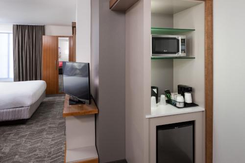 a room with a room with a bed and a microwave at SpringHill Suites by Marriott Salt Lake City Airport in Salt Lake City