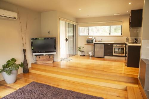 a large living room with a large flat screen tv at Little Norfolk Bay Events and Chalets in Taranna