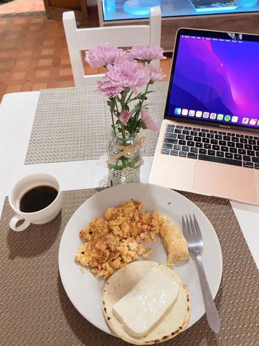 Un plato de comida en una mesa con una computadora portátil. en Ayenda Habana Vieja 1221, en Medellín