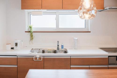 a kitchen with a sink and a window at Lampstand STAY Sapporo-House A in Sapporo