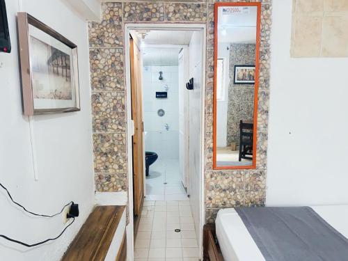 a small room with a bed and a mirror at Ayenda Habana Vieja 1221 in Medellín