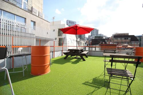 um pátio com uma mesa e um guarda-chuva no telhado em Bunk Guesthouse Hongdae em Seul