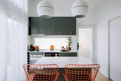a kitchen with a white table and two chairs at Retro Retreat - by Coast Hosting in Terrigal