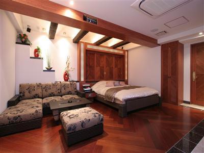 ホテル　Kirara في Kurosu: غرفة معيشة مع سرير وأريكة