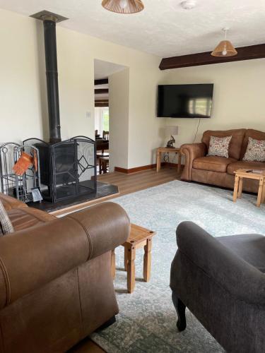 a living room with a couch and a fireplace at Braffin @ Fellside Farm, Pennington, Ulverston in Pennington