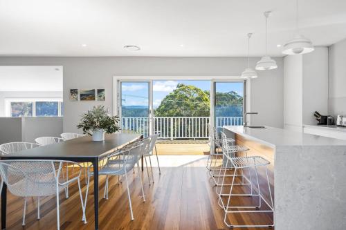 a kitchen and dining room with a table and chairs at Coastal, Pet-Friendly Luxe in Narrawallee