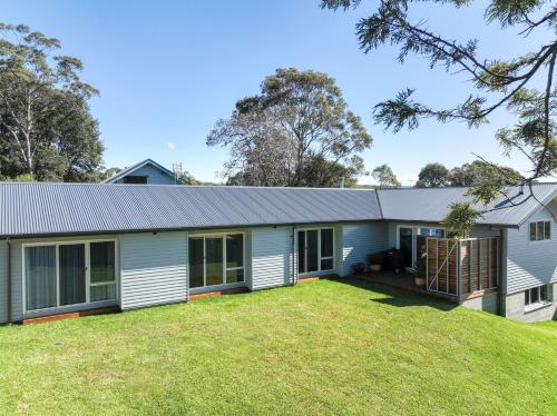 an exterior view of a house with a large yard at Coastal, Pet-Friendly Luxe in Narrawallee