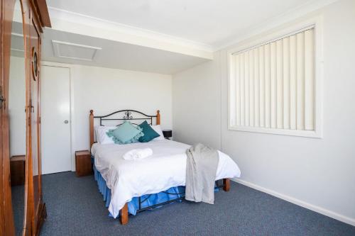a bedroom with a bed and a window at Wave Spray in Burrill Lake