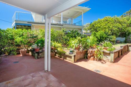 an outdoor patio with potted plants and a building at Wave Spray in Burrill Lake