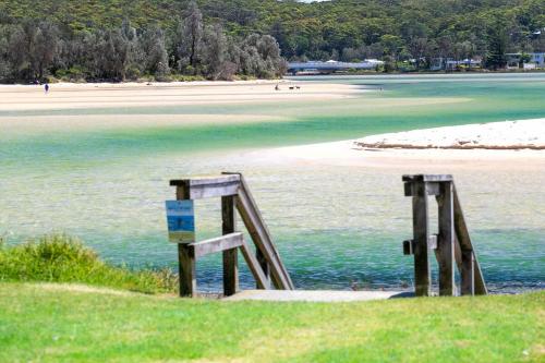 a view of a beach with a sign in the water at Wave Spray in Burrill Lake