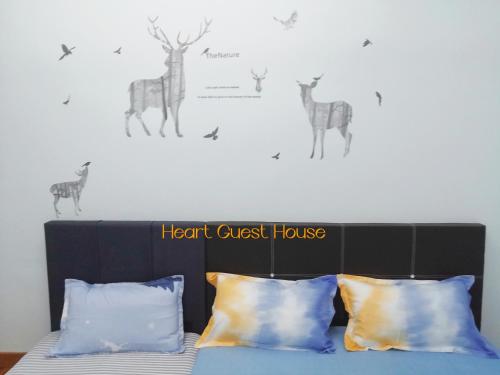 a bedroom with a bed with a headboard with deer on the wall at Heart Bentong Guest House 文冬心宿民宿 Bentong Homestay in Bentong