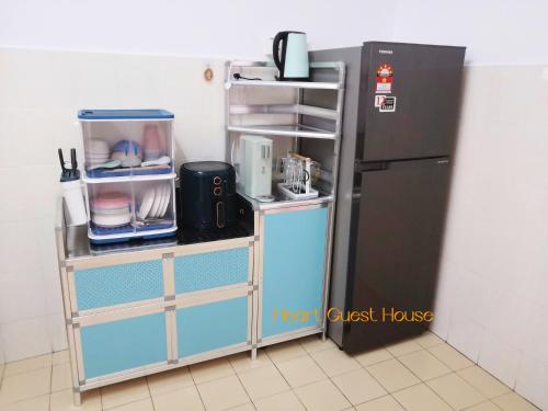 a kitchen with a shelf next to a refrigerator at Heart Bentong Guest House 文冬心宿民宿 Bentong Homestay in Bentong