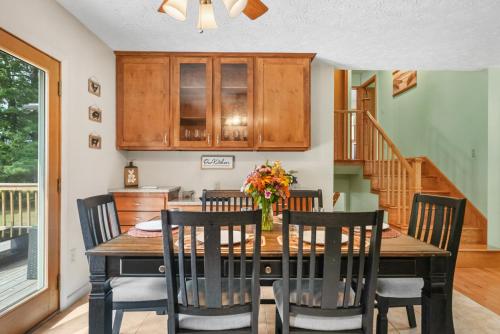 a dining room with a wooden table and chairs at LAKEFRONT PARADISE 4 bedroom Home w direct lake access, Pets OK in Traverse City