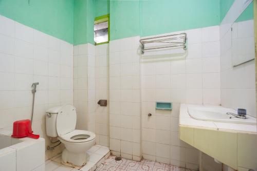 a bathroom with a toilet and a sink at Reddoorz Syariah At Hotel Matahari 2 in Jambi